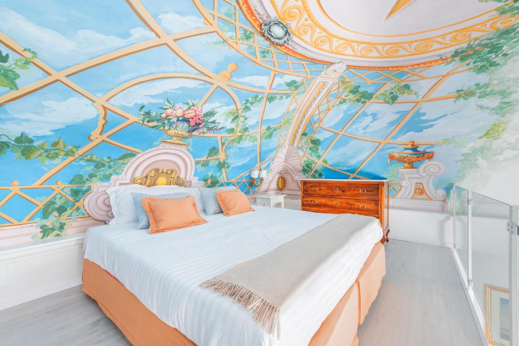 una camera da letto con un letto e un dipinto sul soffitto di Palazzo Sassi a Meta