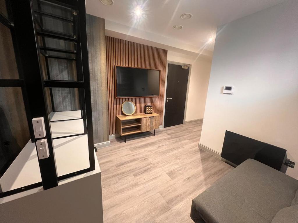 a living room with a couch and a television at The Jesmond Hideaway - Cosy Modern Apartment in Jesmond