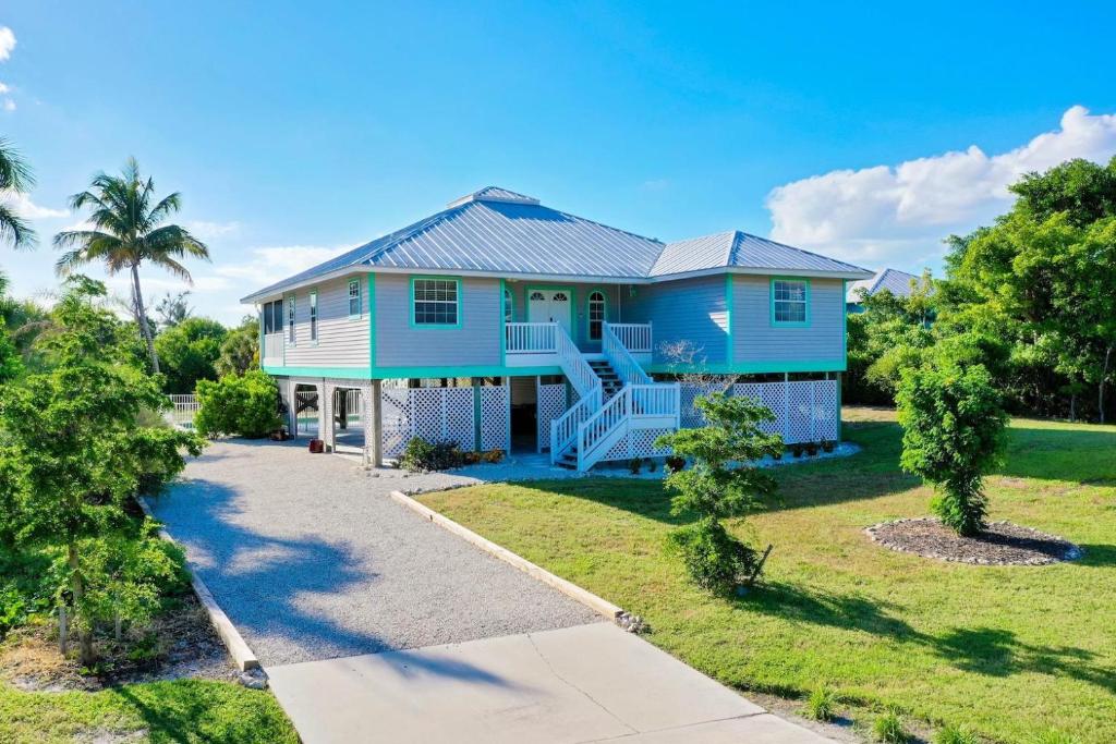 a blue house with a porch and a driveway at Casa Al Mare in Sanibel Island