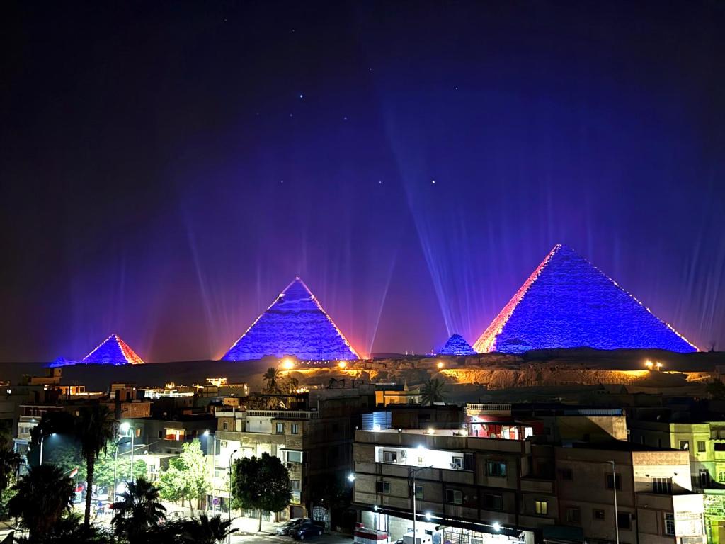 a view of the pyramids lit up at night at Continental Pyramids Terrace Hotel in Cairo