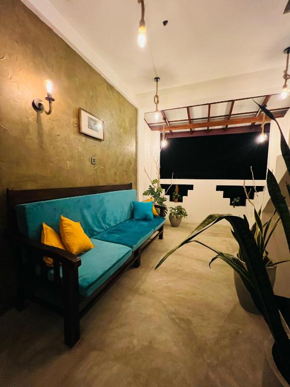 a living room with a blue couch and a blackboard at MUSA Holiday Inn in Dodanduwa