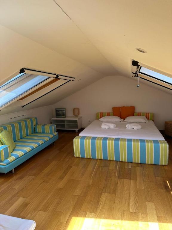 a bedroom with a bed and a couch in a attic at Quinta do Cutato - Beatriz Guest House - Sotão in Santo Estêvão