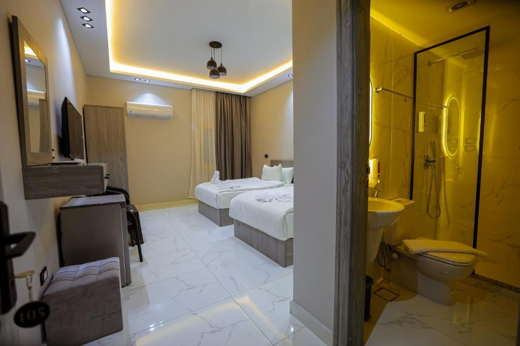 a hotel room with two beds and a bathroom at Cairo soul Hotel in Cairo