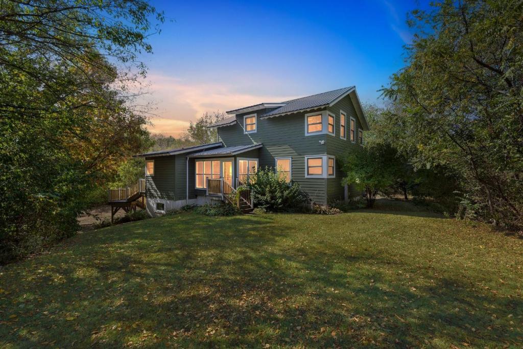 a house on a hill with a grass yard at Secluded Woodland Retreat Near Starved Rock Park home in Grand Ridge
