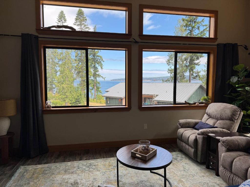 a living room with windows and a couch and a table at Sequim Bay Hideaway in Sequim