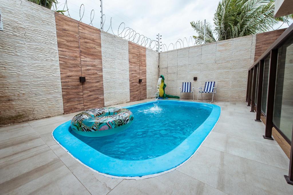a swimming pool in the middle of a patio at Casa em Jacuma, com piscina, 5 suites e fliperama in Jacumã