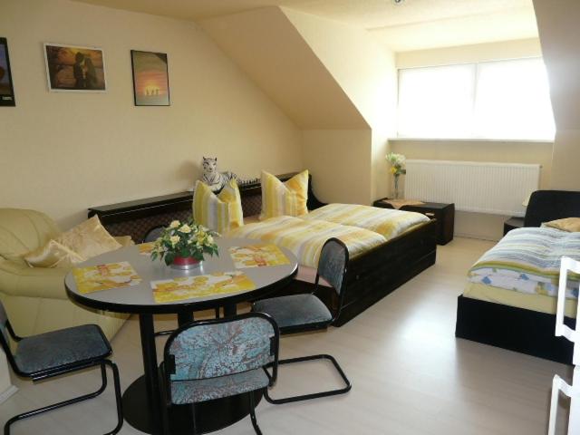 a bedroom with a bed and a table and chairs at Caruso Pension und Pizzeria in Salzweg