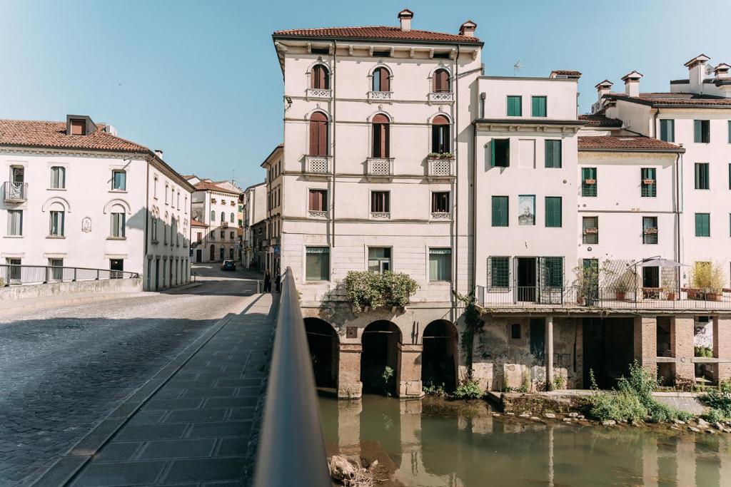 ヴィチェンツァにあるPalladio Apartment - Vista Fiume, In Centro con Garageの建物が立ち並ぶ都市の川にかかる橋