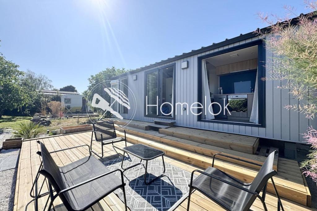une terrasse avec des chaises et des tables sur une maison dans l'établissement Bungalow & caravane vintage proche plages, à Ploemeur