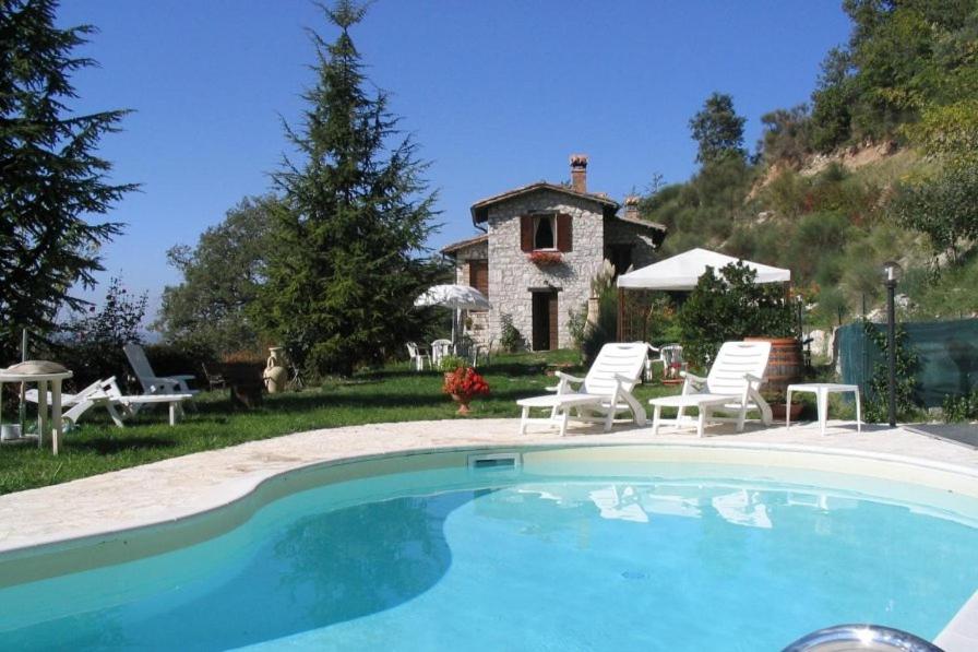 a large swimming pool in front of a house at Vigna Renaro Elegant in Gubbio
