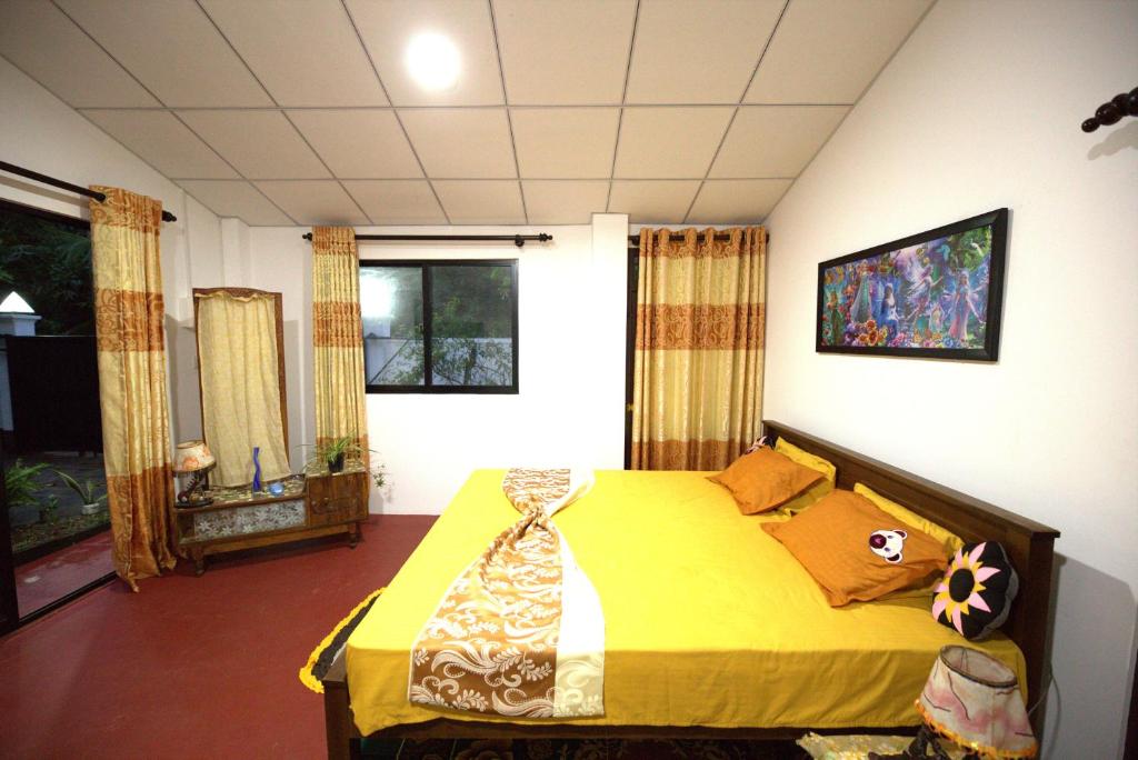 a bedroom with a yellow bed in a room at New Look villa in Mirissa