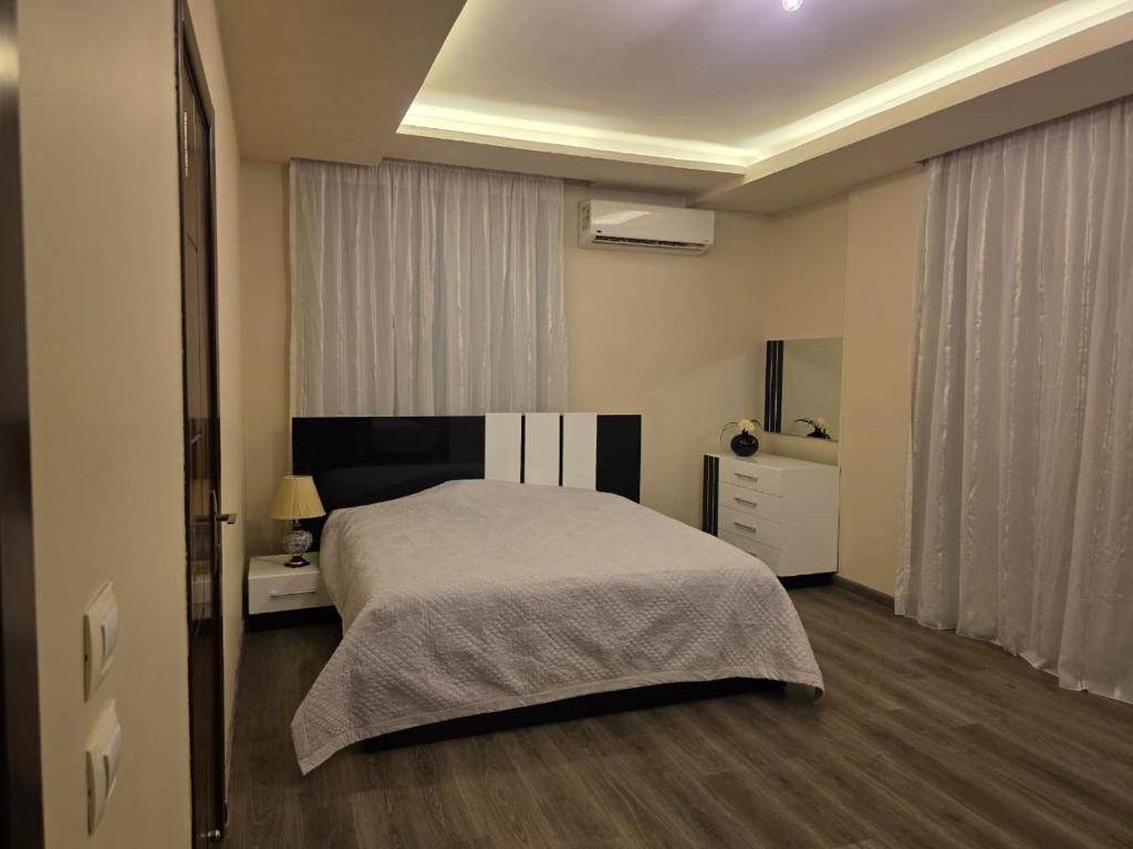 a bedroom with a bed and a dresser and a window at South B Paradise in Cairo