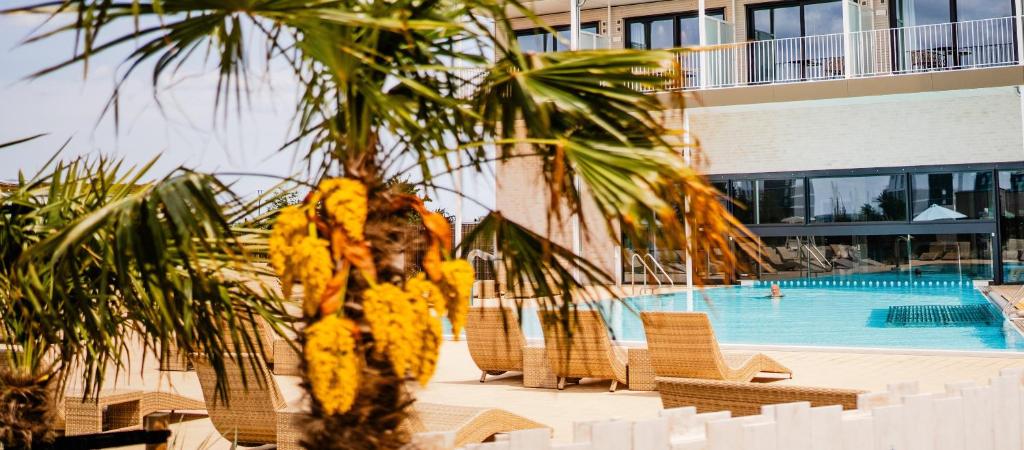 palma di fronte alla piscina di SlowDown Bottsand Hotel und Spa a Wendtorf