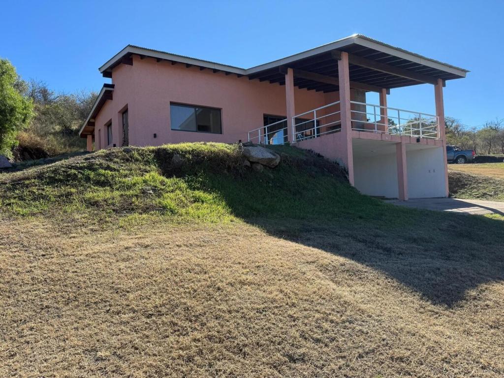 a house on top of a grassy hill at Sierras de Córdoba Ascochinga in La Pampa