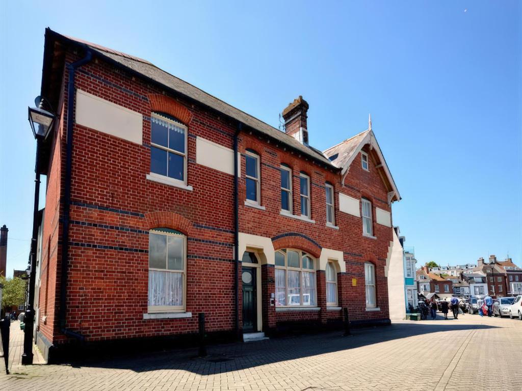 ein rotes Backsteingebäude in einer Stadtstraße in der Unterkunft Mutiny House in Weymouth