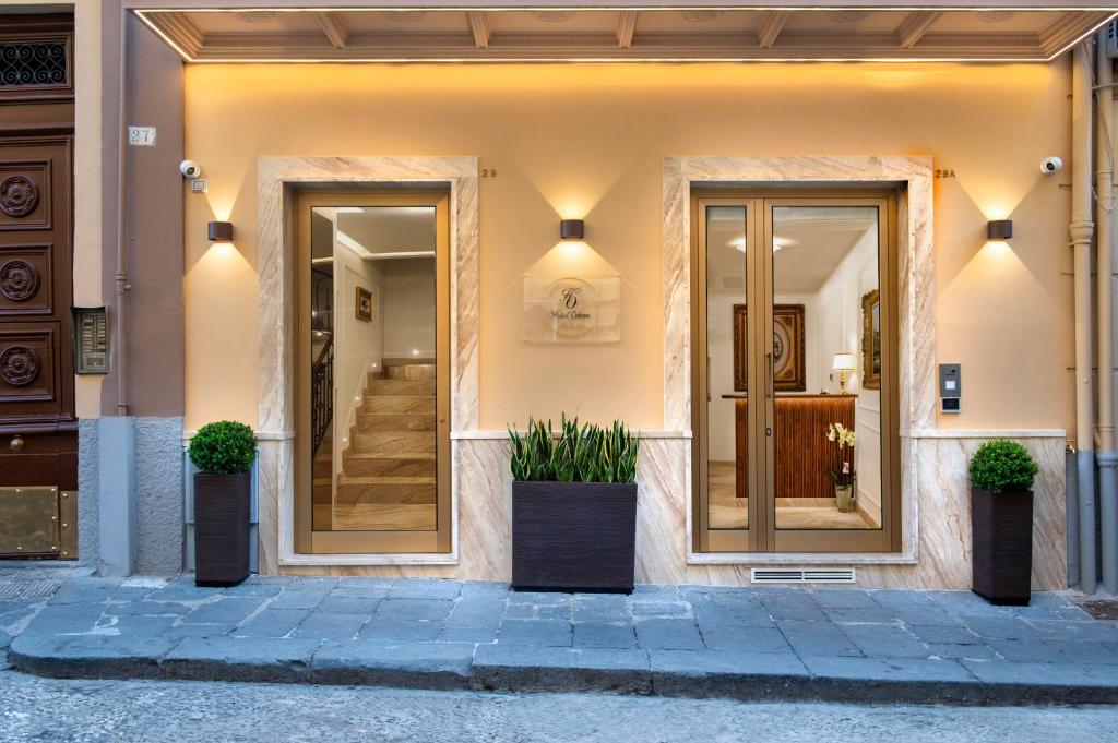 a facade of a building with two doors and potted plants at Hotel Odeon Napoli in Naples