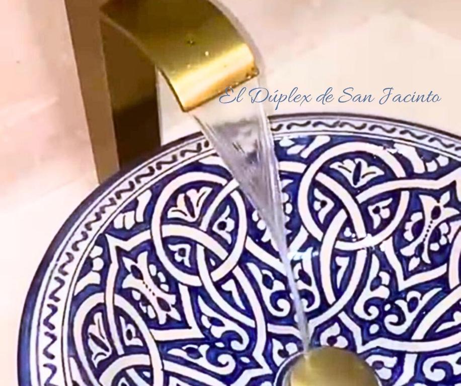 un coltello che taglia un piatto blu e bianco di El Dúplex de San Jacinto a Siviglia