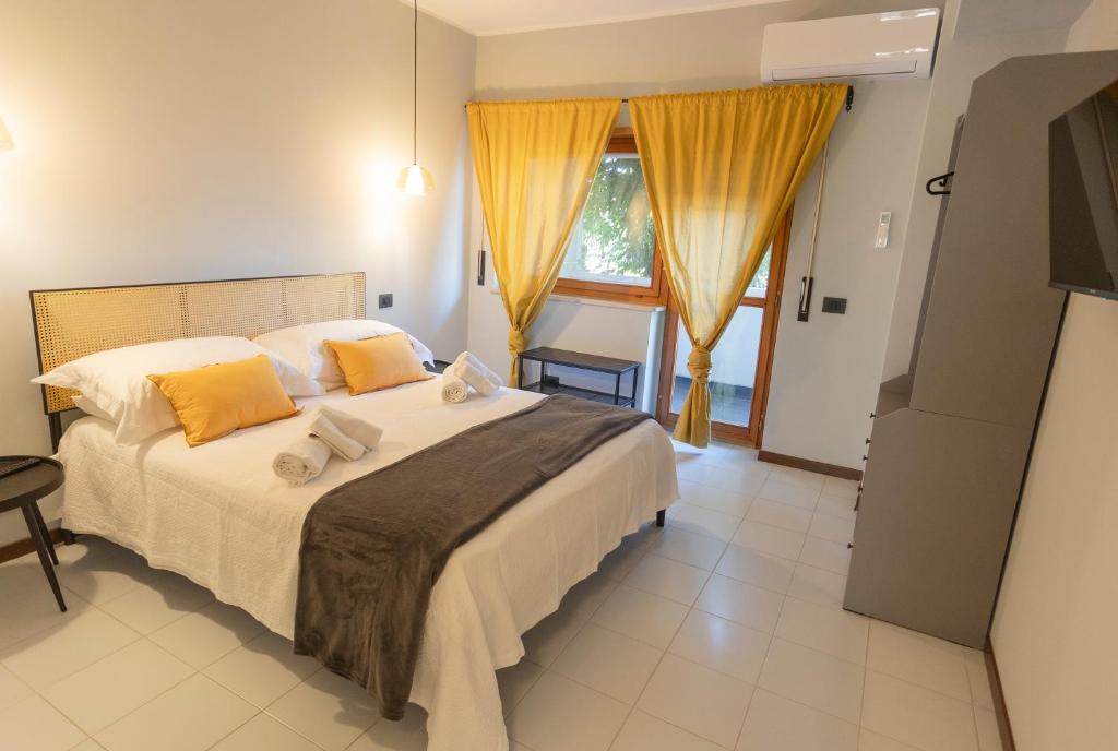 Schlafzimmer mit einem großen Bett und gelben Vorhängen in der Unterkunft Casa Viola in Reggio di Calabria