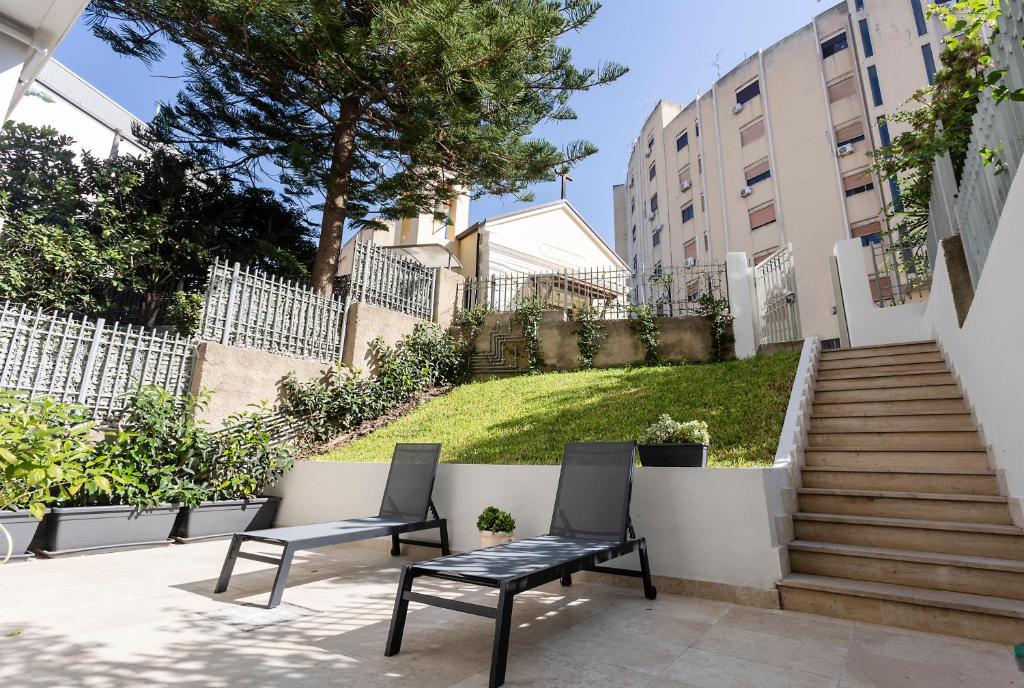 two chairs sitting on a patio in front of a stairs at Casa Viola in Reggio di Calabria