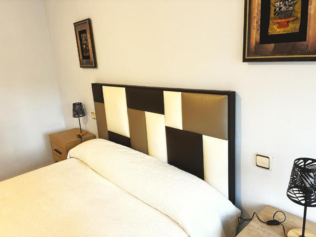 a bedroom with a bed with a black and white headboard at Casa De La Virginia in Valdealgorfa