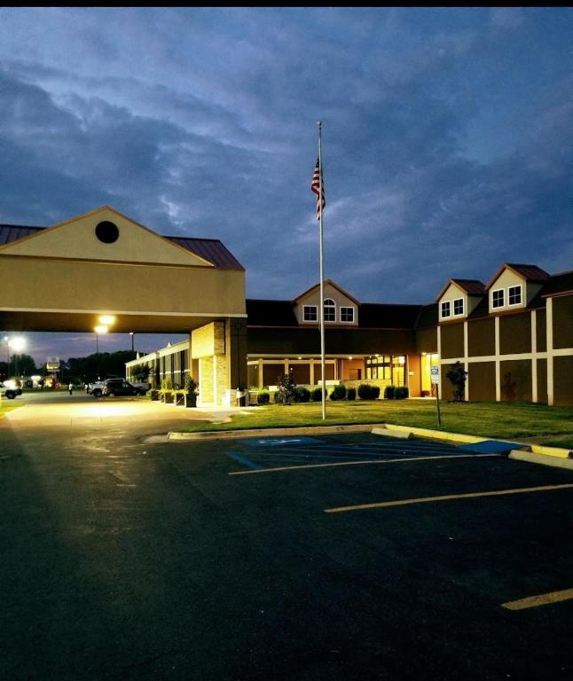 een lege parkeerplaats voor een gebouw met een vlag bij LeBossier Hotel in Bossier City