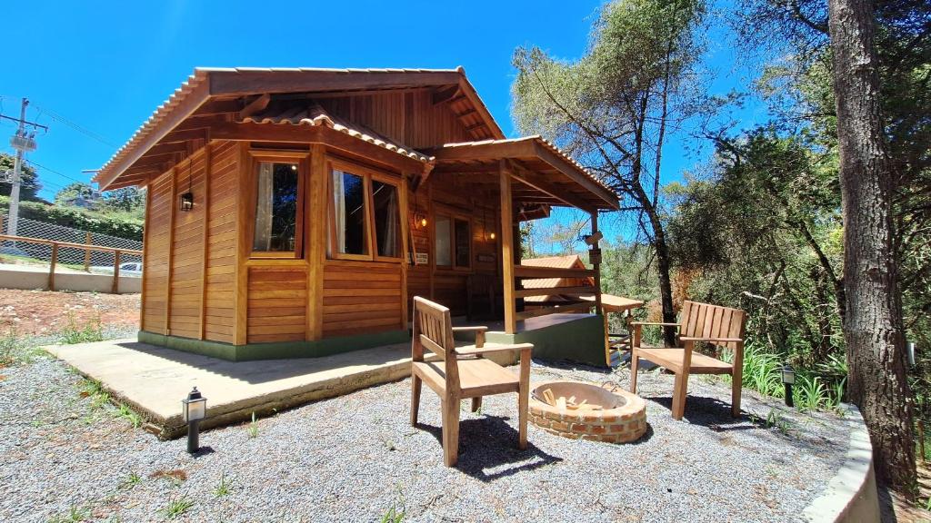 a small wooden cabin with two chairs and a fire pit at Folk Cabin in Monte Verde