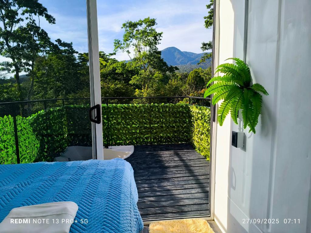 Una habitación con balcón con cama y vista. en Tucan container, en Tapantí