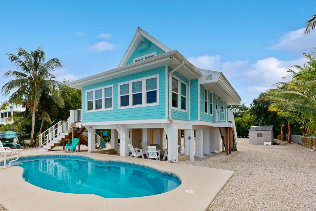 a blue house with a pool in front of it at Sunset Sanctuary in Marathon