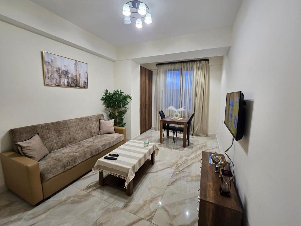 エレバンにあるYour Yerevan Homeのソファとテーブルのあるリビングルーム