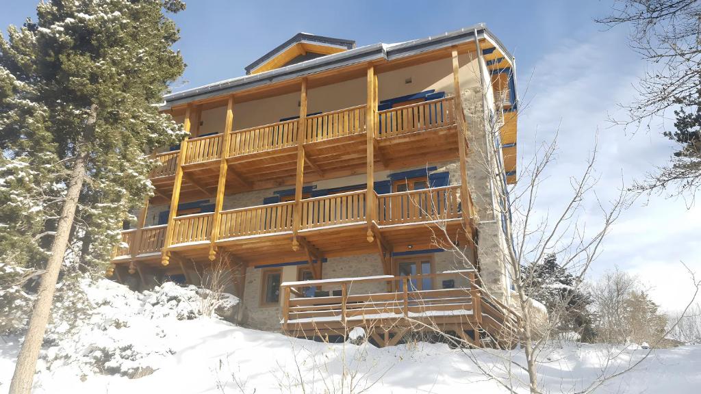 a large wooden building in the snow at Lis Martagon in Font-Romeu