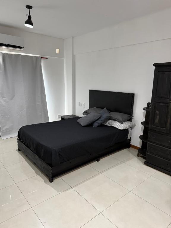 a bedroom with a black bed and a black dresser at Loft Boutique Premium - Design and Comfort in Berazategui