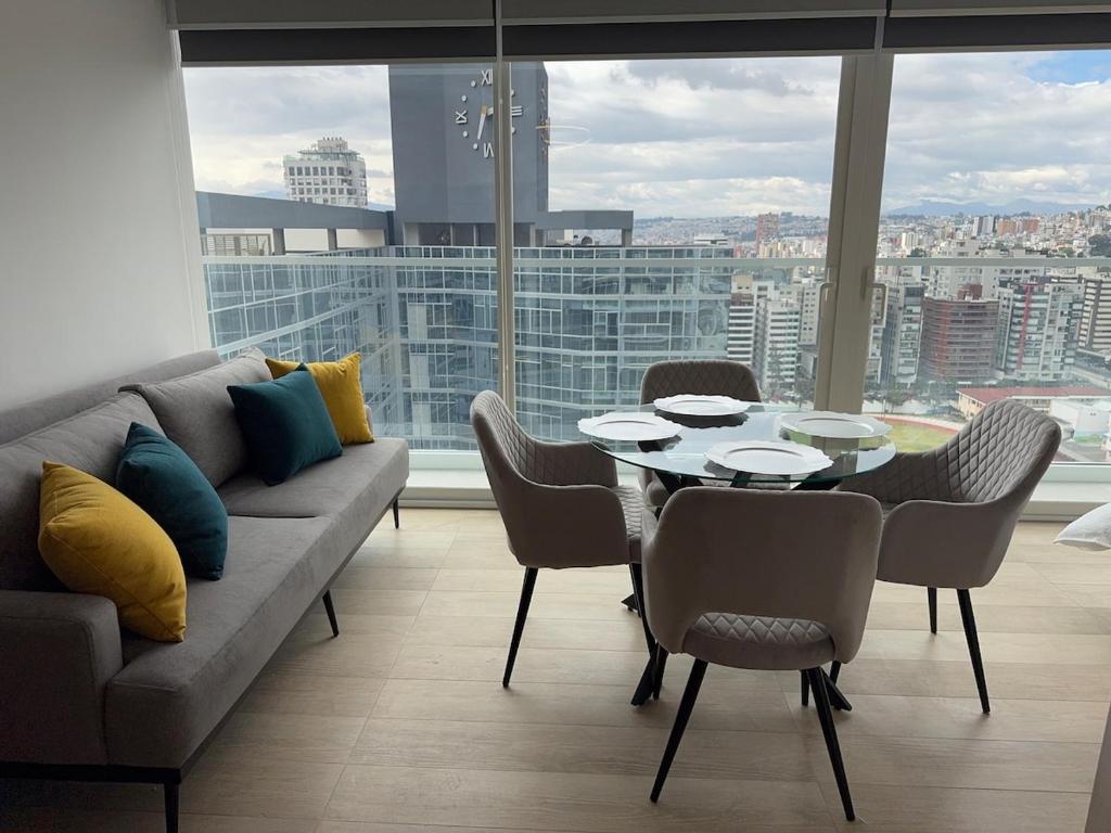 a living room with a couch and a table and chairs at Nuevo Studio en Edificio Qanvas- Piso 19 - Parque La Carolina in Quito