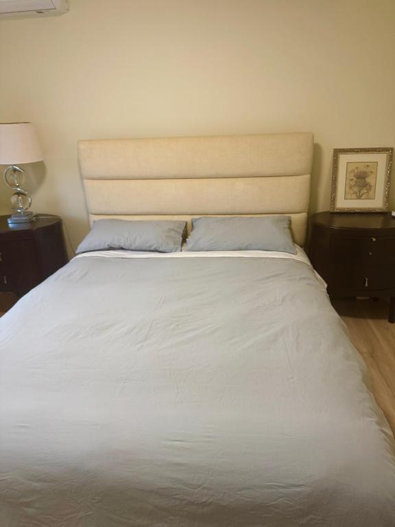 a large white bed with two pillows on it at Maple & Moon in Richmond