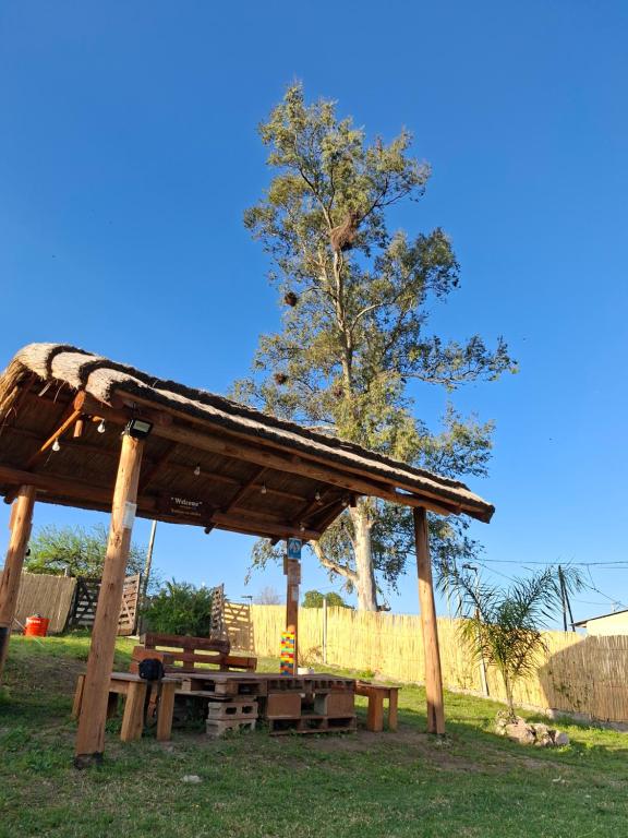 a wooden pavilion with a picnic table and a tree at Estación La Perla in Alta Gracia