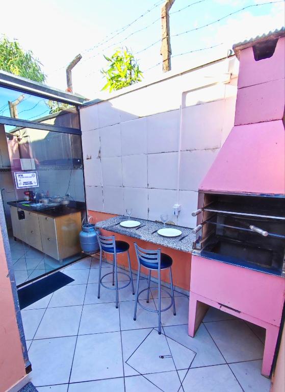 a patio with a table and chairs and a grill at Casa Studio"' São José dos Campos in São José dos Campos