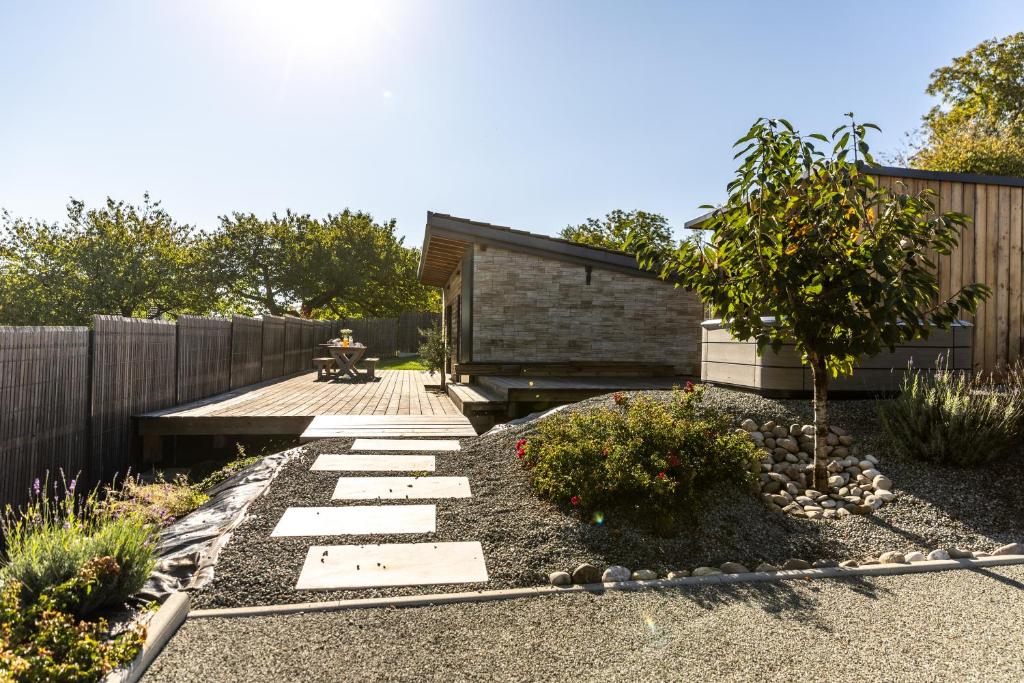 un jardín con una pasarela de piedra junto a una valla en Bergerie bien être, en Vaivre-et-Montoille