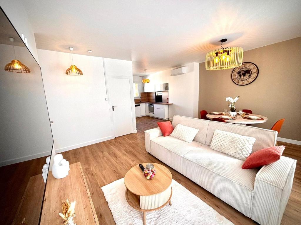 un salon avec un canapé blanc et une table dans l'établissement La bohème du clocher - Cosy calme hyper-centre 2 à 6 pers, à Bergerac