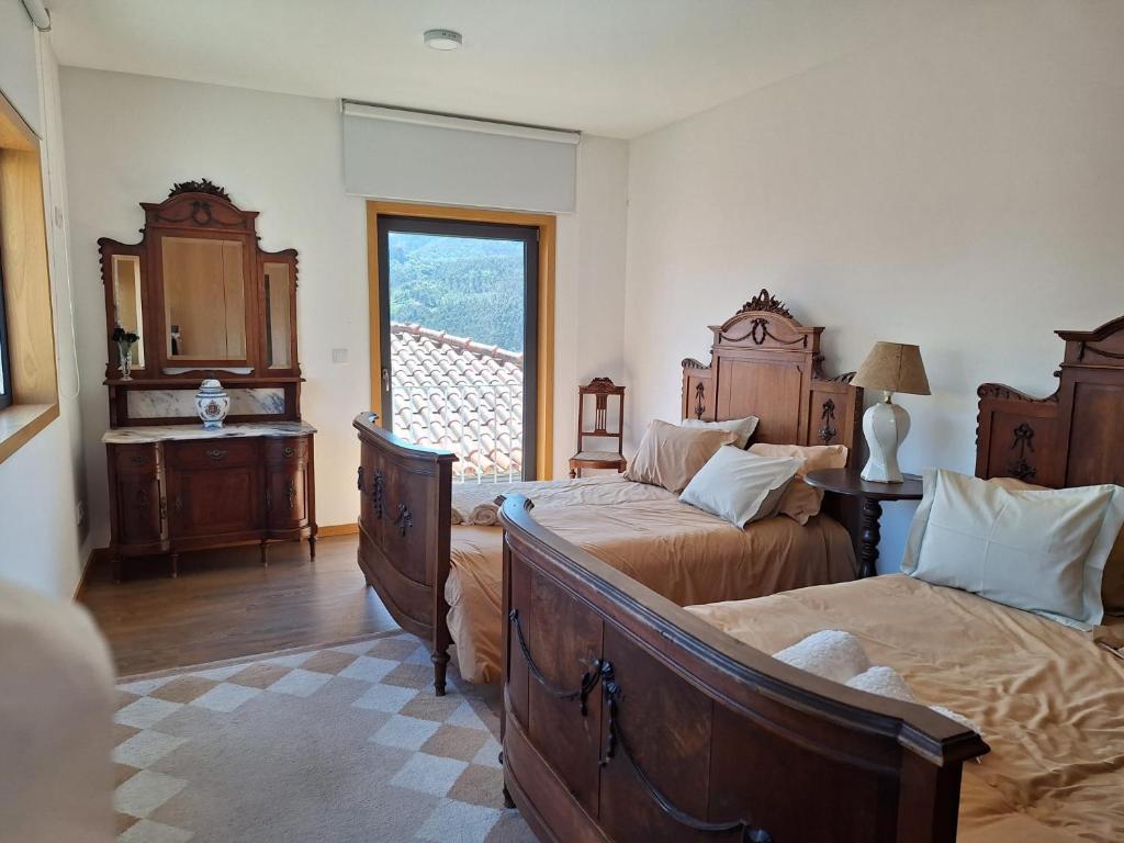 ein Schlafzimmer mit zwei Betten und einem Fenster in der Unterkunft Casa Vilarinha Gerês in Taboabela