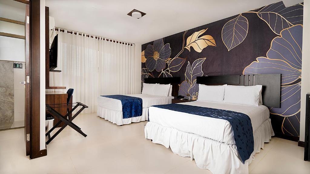 a bedroom with two beds and a wall with flowers at Mai Suites Apart Hotel in Santa Cruz de la Sierra