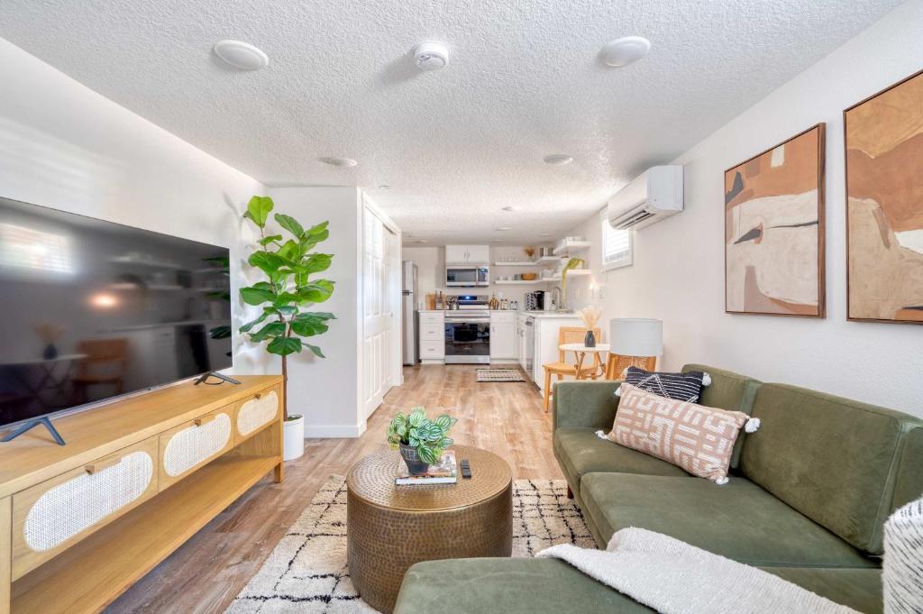 Una sala de estar con un sofá verde y una mesa. en Stay Portland - Vibrant Portland Getaway, Chic Flat, en Portland