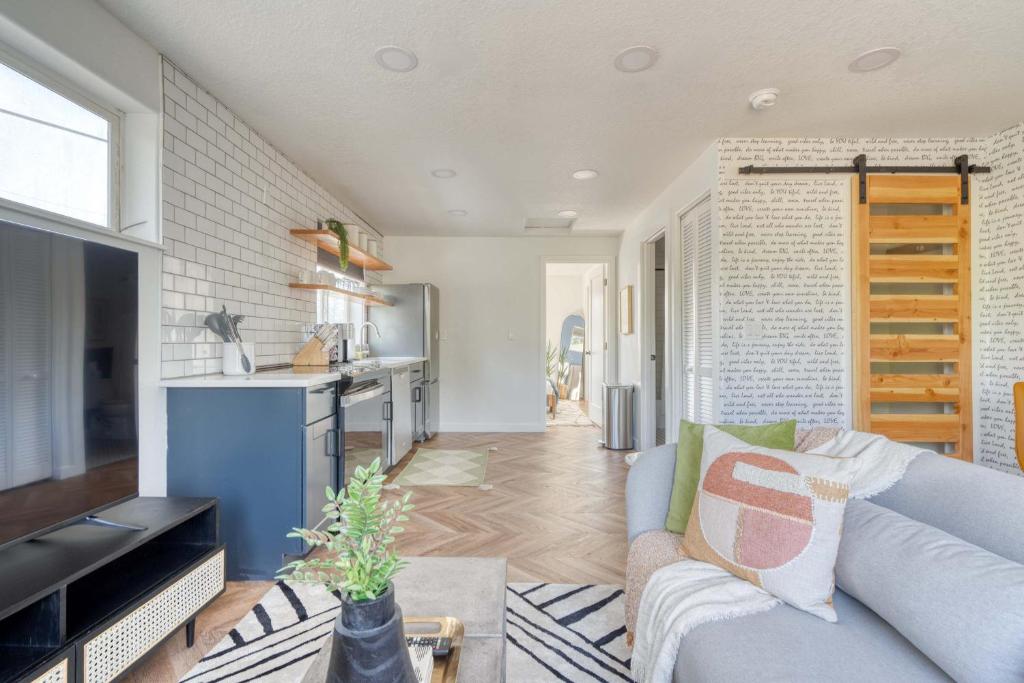Stay Portland - The Perfect Artist's Retreat in Woodstock في بورتلاند: غرفة معيشة مع أريكة ومطبخ