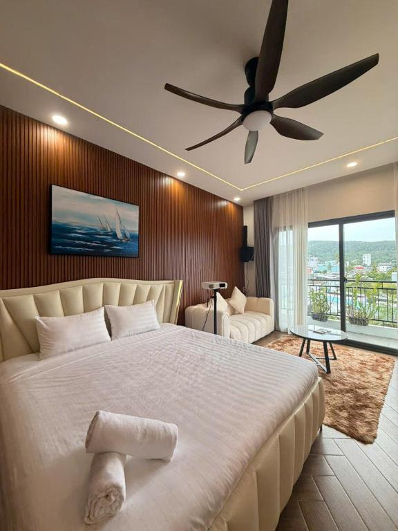 a bedroom with a large bed with a ceiling fan at JonHouse in Phu Quoc