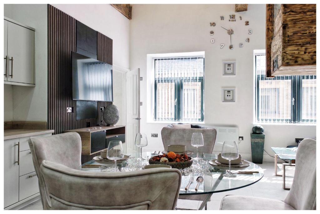 a dining room with a glass table and chairs at 1Bed Apt- Sleeps 6 City Center Jacuzzi Bath Wifi in Bradford
