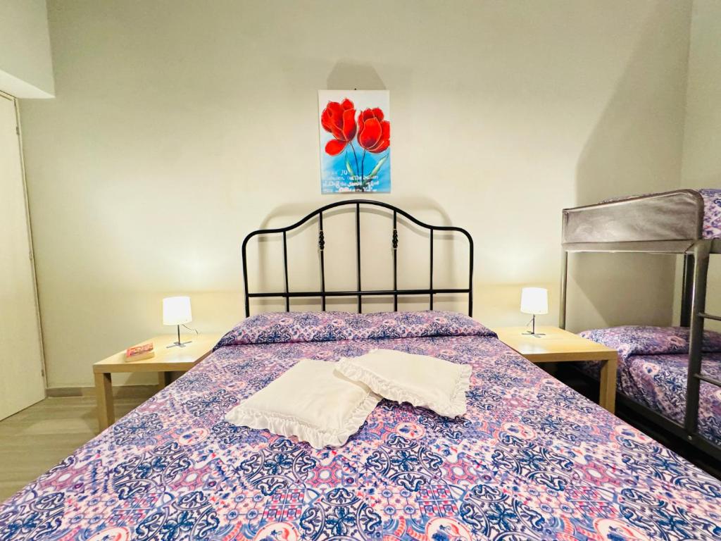 a bedroom with a bed with two tables and a painting on the wall at Angelia in Capaci