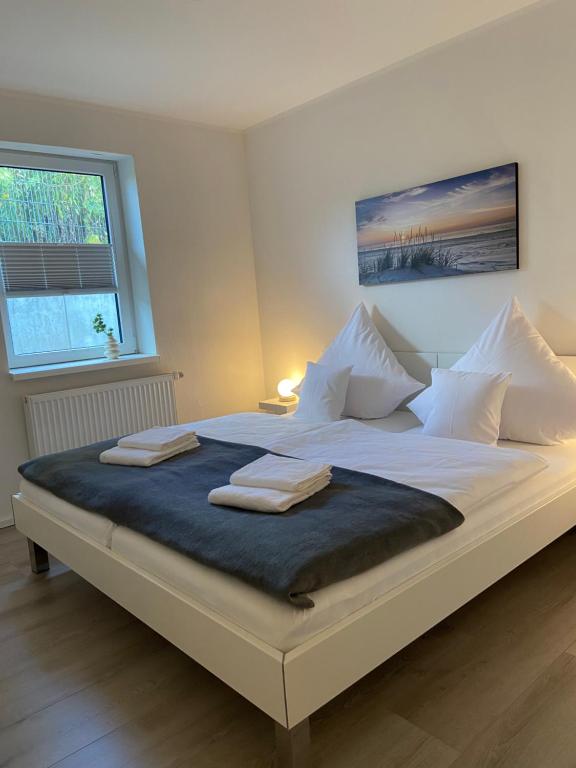 a large white bed with two towels on it at FeWo Diemelblick in Diemelsee