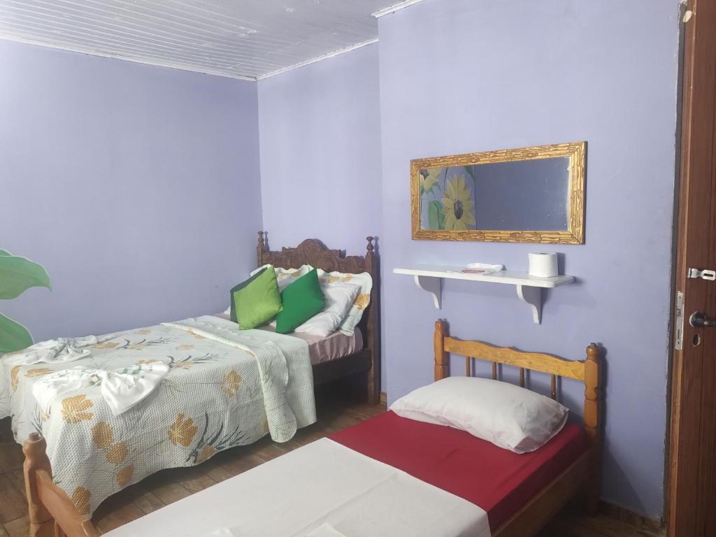 a room with two beds and a mirror at Pousada Dádiva girassol encantado Pontal Centro in Paraty