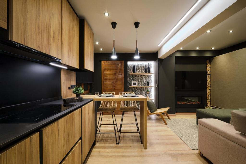 une cuisine avec une table et un salon dans l'établissement El Harapan - Suite boutique selva a pie de playa - Grupo Querbes, à Gijón