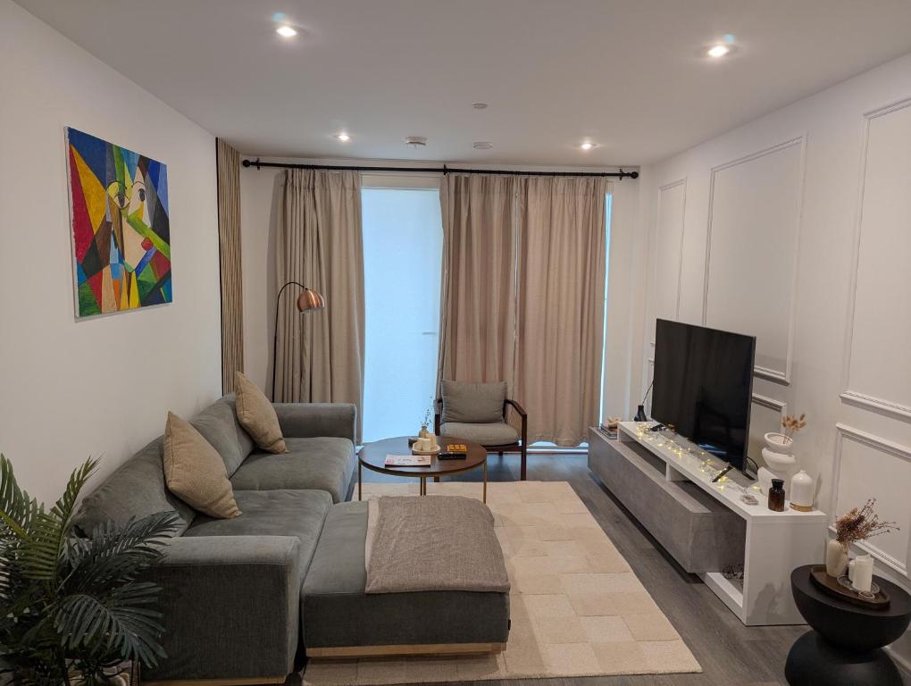 a living room with a couch and a tv at Modernistic 2 Bed - 2 Bath Flat near Central London in London
