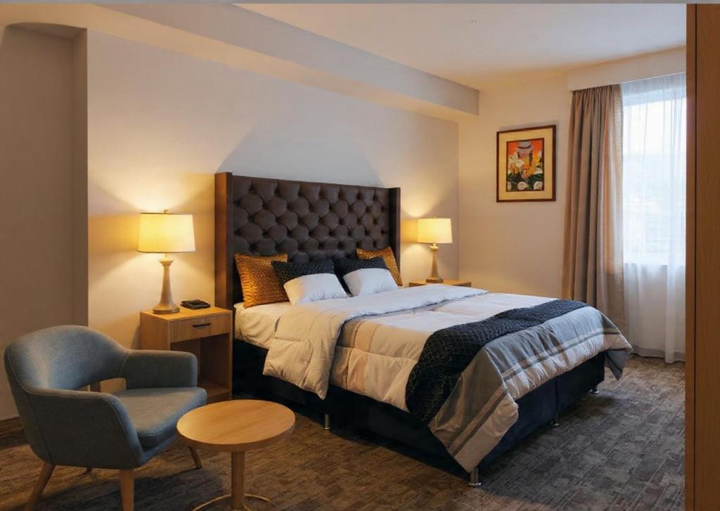 a hotel room with a bed and a chair at Hospedaje Aqquazul Ayacucho in Ayacucho