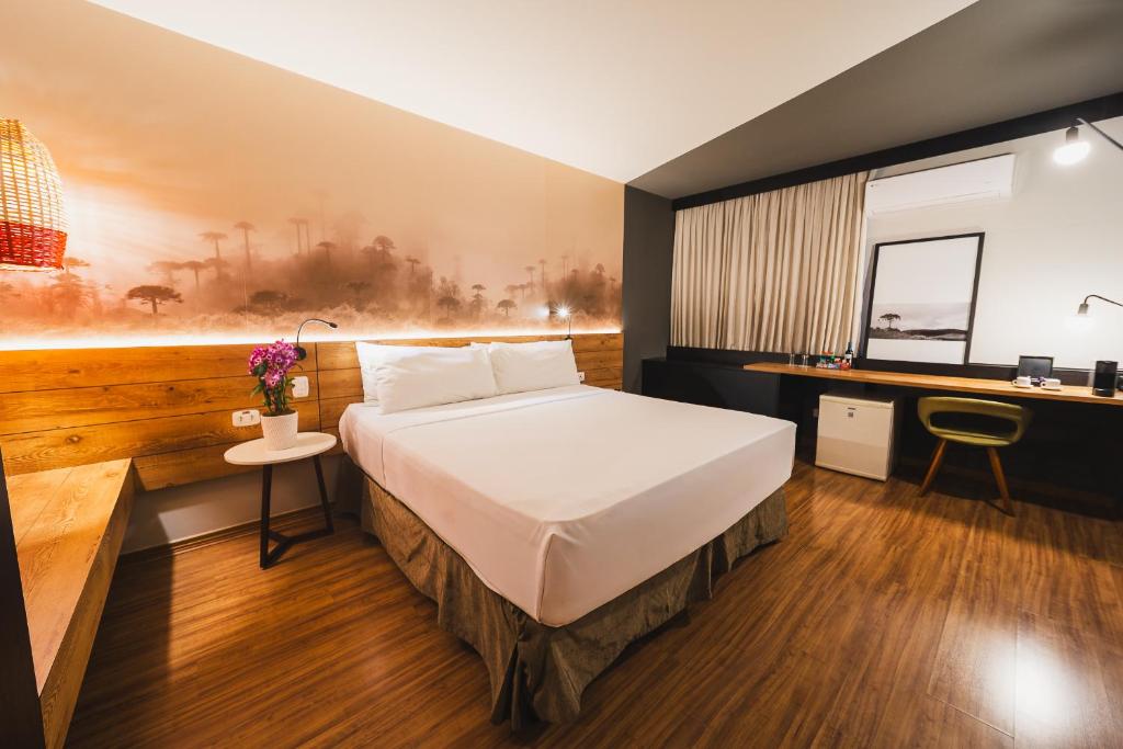 a hotel room with a bed and a desk at Hotel Cassino Tower Curitiba Aeroporto By Nacional Inn in São José dos Pinhais